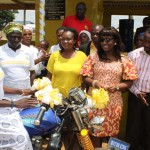 MRS FIAGBENU HANDING OVER THE  KEYS TO THE TRICYCLE TO A   MEMBER OF SUNG SUMA WOMEN GROUP